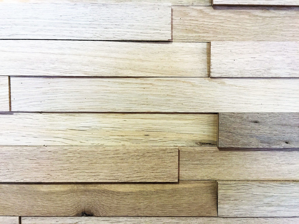 Mur de lattes de bois clair superpos&eacute;es